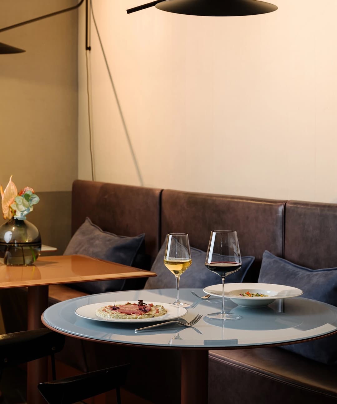 Mesa sin comensales con platos y copas